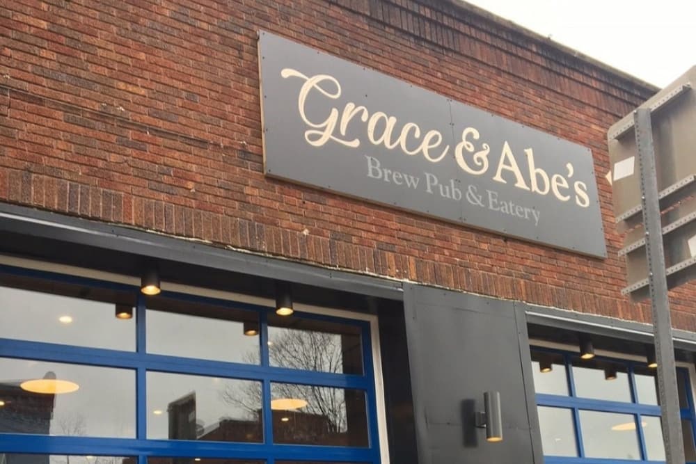 Sign for "Grace & Abe's Brew Pub & Eatery" on a brick building.